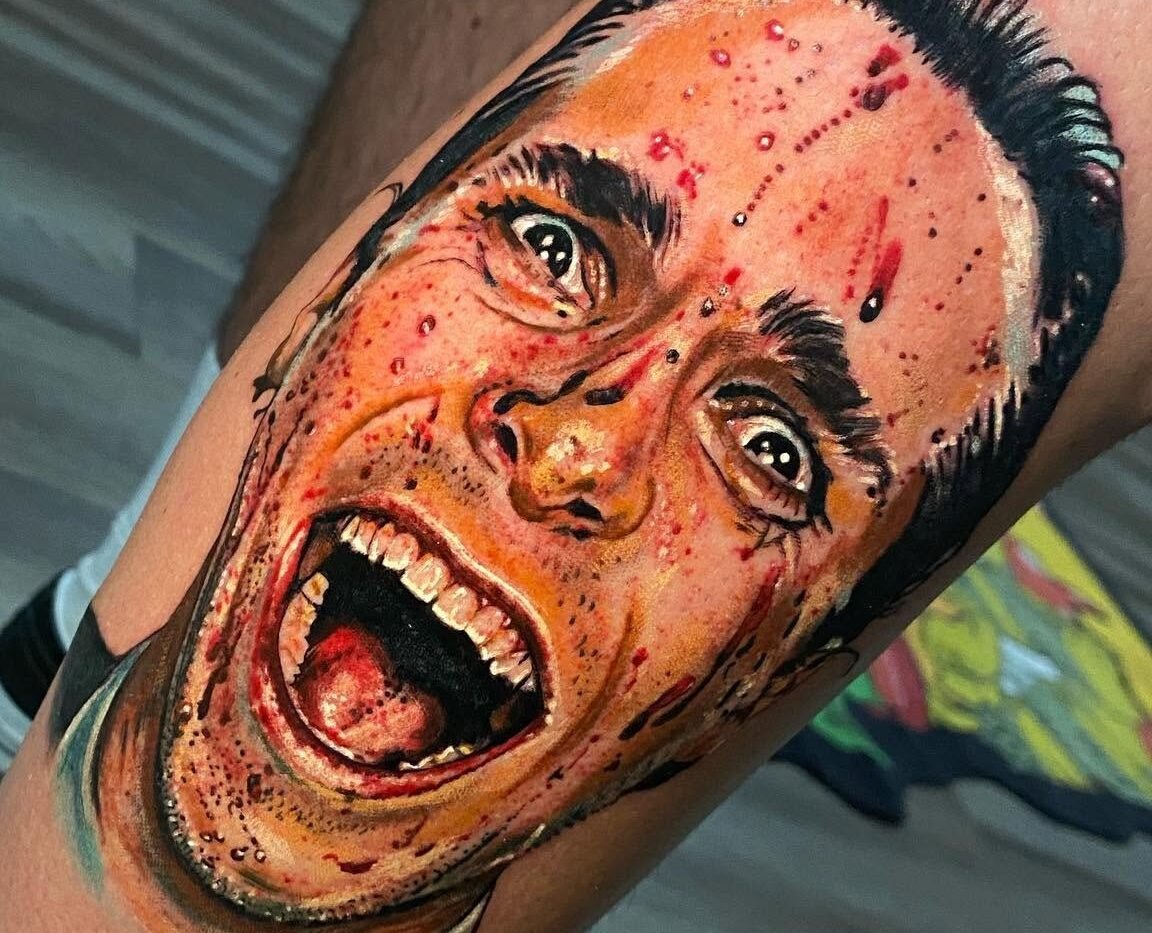 Colour realism portrait tattoo of a shouting face on the upper arm