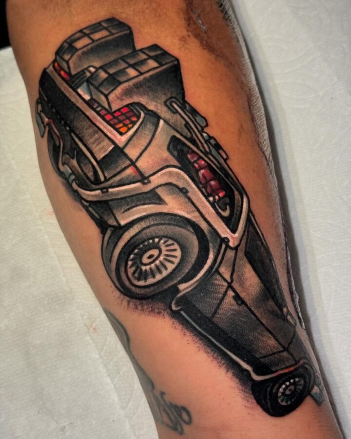 Black and grey realism tattoo of a DeLorean car on the calf