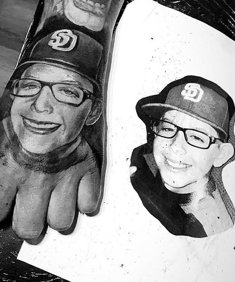 High contrast black and grey memorial portrait tattoo of a father and son