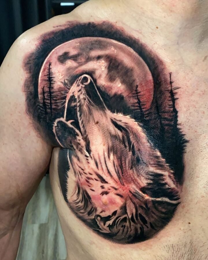 Black and grey howling wolf tattoo with moon and pine trees on the chest