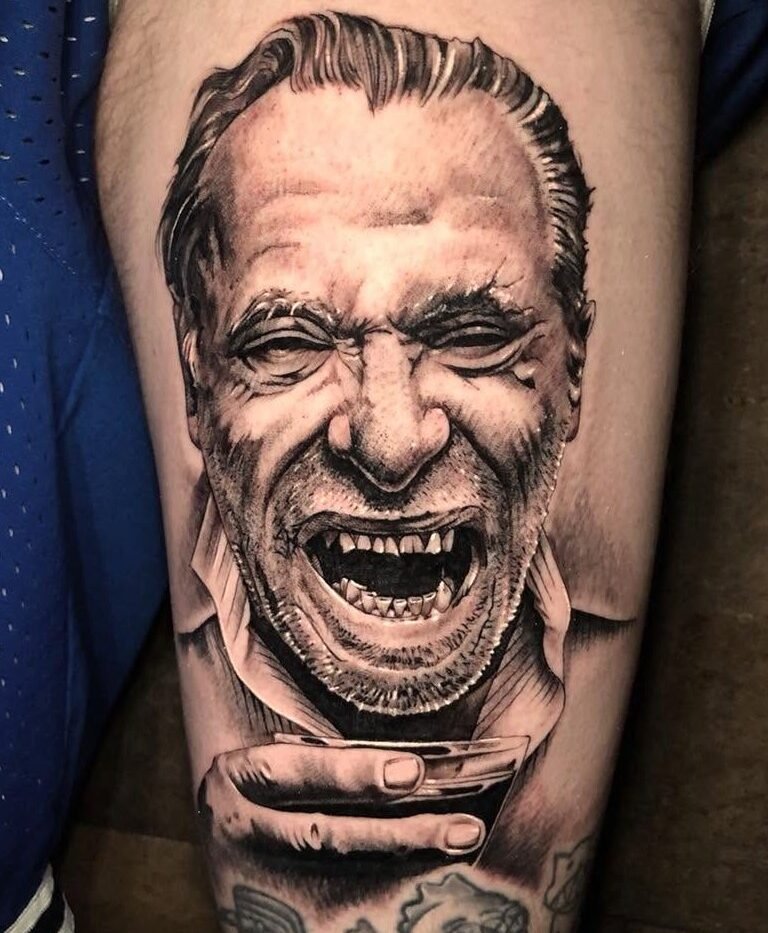 Black and grey photo-realistic portrait tattoo of a laughing man on the forearm
